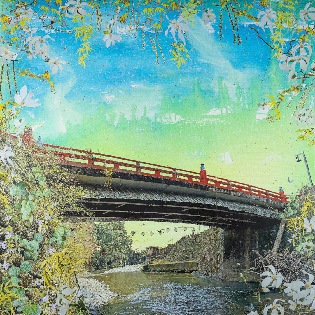 Traditional Japanese bridge with cherry blossoms and a blue sky